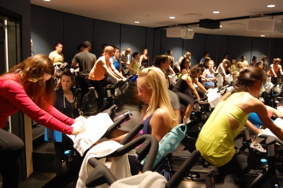 Christina helping a fellow Flyer with her bike before class